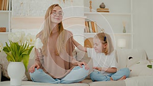 Mindful Caucasian mother calm woman meditating with closed eyes in lotus position doing yoga exercise meditation sit on