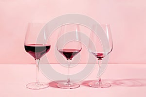 Mindful drinking and alcohol cutback concept. Three glasses with lowering levels of red wine poured