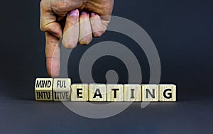 Mindful or intuitive eating symbol. Doctor turns cubes and changes words intuitive eating to mindful eating. Beautiful grey photo