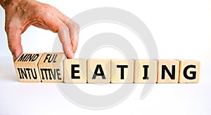 Mindful or intuitive eating symbol. Doctor turns cubes and changes words intuitive eating to mindful eating. Beautiful white photo