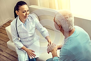 Mindful medical worker listening to thankful elderly patient