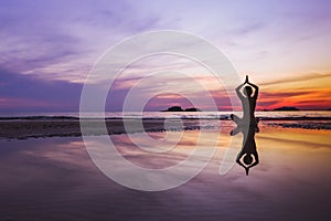 Mindfulness and meditation background, silhouette of woman doing yoga on the beach