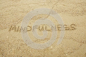 Mindfulness written on sand.
