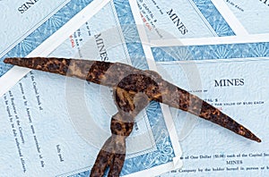 Mine stock certificates with rusted pick