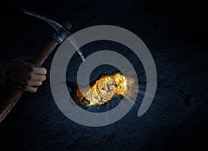 Miner digging golden bitcoins with a pickaxe photo