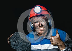 Miner dirty hands holding piece of coal mine
