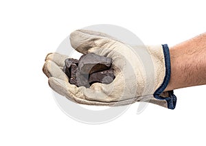 Miner hand with protective glove holding metallic rock,  white background. Steelmaking or mining concept