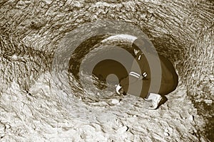 Miner man underground in a mine tunnel. Worker in overalls, safety helmet