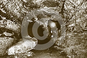 Miner man underground in a mine tunnel. Worker in overalls, safety helmet