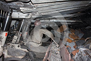 Miner working in a confined space clears from the conveyor.