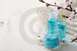 Mineral bath salts, shower gel, towels and flowers on the wooden table