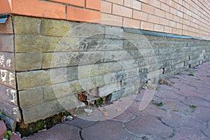Mineral Efflorescence and wet foundation wall cracks - warning signs. House foundation repair. Broken wet foundation house brick photo