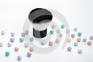 Mineral powder pearls and kabuki makeup brush, up close view.