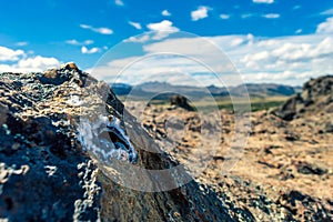 Mineral rock in the foreground with a mountain range in the background. Natural resources. Concept of wealth in nature