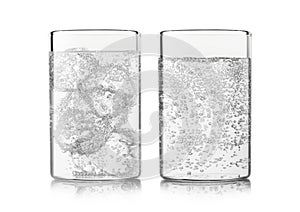 Mineral sparkling water with ice cubes and bubbles on white background