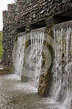 Mineral spring. Stream in the SPA. Curative water. Resort. Waterfalls. Summer. Clear and fresh water on the stone wall