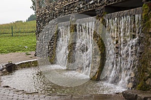 Mineral spring. Stream in the SPA. Curative water. Resort. Waterfalls. Summer. Clear and fresh water on the stone wall