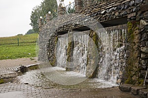 Mineral spring. Stream in the SPA. Curative water. Resort. Waterfalls. Summer. Clear and fresh water on the stone wall