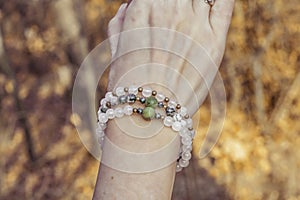 Mineral stone bracelet on female hand detail in forest