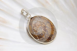 Mineral stone pendant on white shell background