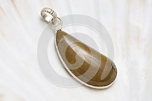 Mineral stone pendant on white shell background