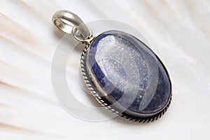 Mineral stone pendant on white shell background