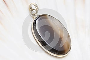 Mineral stone pendant on white shell background