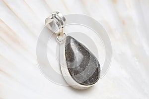 Mineral stone pendant on white shell background