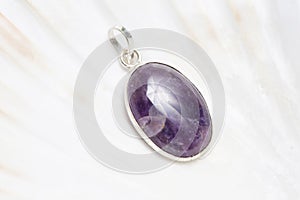 Mineral stone pendant on white shell background