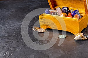 Mineral stones in a wooden jewelry box. The concept of using minerals in astrology. Copy space