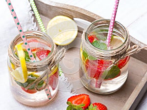 Mineral water with fresh strawberries, lemon and mint in jar