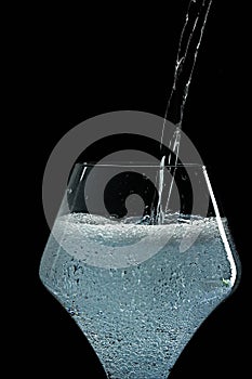 Mineral water is poured into a glass.