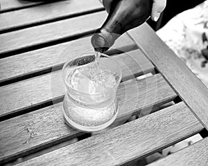 Mineral water is poured into a glass on a table