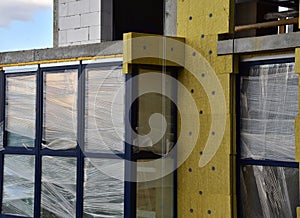 Mineral wool insulation of the facade building on construction site. Thermal protection of house. Installation double-glazed