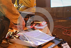 Miners removing personnel safety isolation lock and sign of the work at height permit on isolation lock box after completed hight