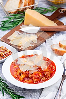 Minestrone soup with cavatappi pasta, beans and vegetables, served with crispy bread, vertical