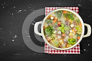 Minestrone soup on the dark background. Rustic style