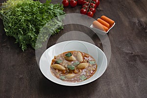 Minestrone soup with pasta and herbs. Italian Cuisine. Dark wooden background. Place for text