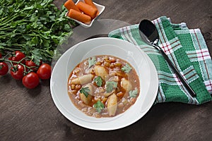 Minestrone soup with pasta and herbs. Italian Cuisine. White wood background. Place for text