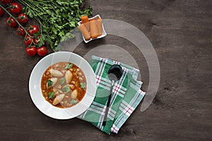 Minestrone soup with pasta and herbs. Italian food.Dark wooden background. Place for text