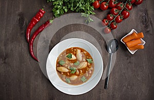 Minestrone soup with pasta and herbs. Italian food.Dark wooden background. Place for text