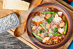 Minestrone vegetable soup with beans, cauliflower, tomatoes, close-up, top view