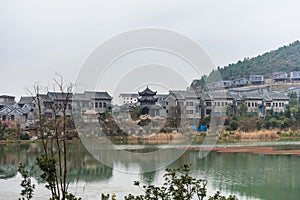 Ming Qing Dynasty Chinese traditional rural house at the lakeside, built with black tiles, stone, and bricks, in Qingyan Ancient