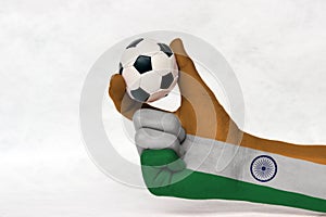 Mini ball of football in India flag painted hand, hold it with two finger on white background.