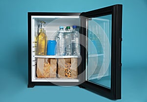 Mini bar filled with food and drinks on turquoise background