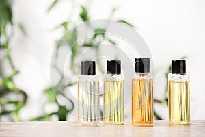 Mini bottles with cosmetic products on table against blurred background.