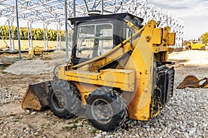 A mini excavator bulldozer is on the construction site.