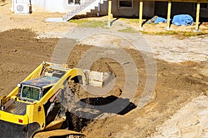 Mini bulldozer with earth doing landscaping works