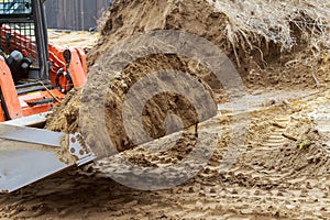 Mini bulldozer with earth doing landscaping works