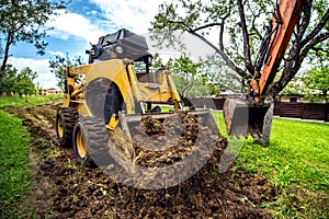 mini bulldozer working with earth, moving soil and doing landscaping works